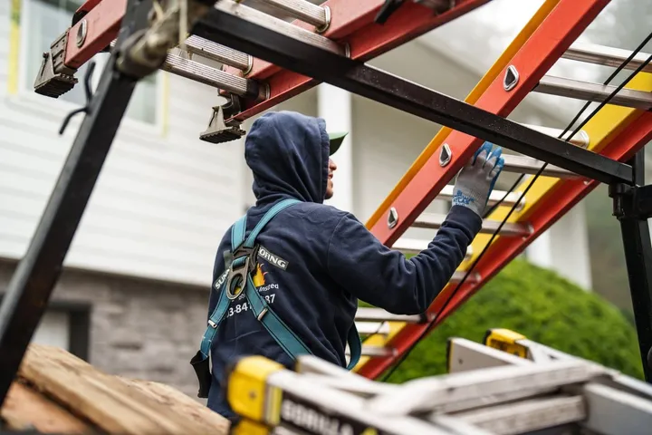 Sunnyside Roofing worker performing roof maintenance at a home